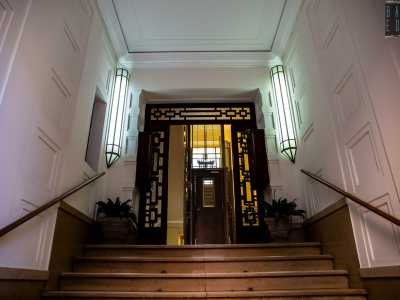 ...che si apre su una scala di ingresso illuminata da due lampade verticali...